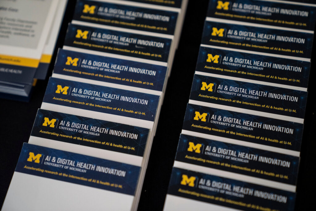 Stacks of blue and white business cards for the University of Michigan's AI & Digital Health Innovation program.